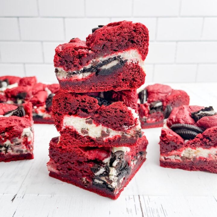 stack of red velvet brownies with red velvet brownie squares in the background
