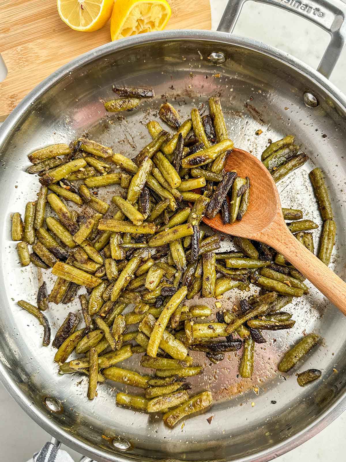 sauteed canned green beans in a stainless steel skillet.