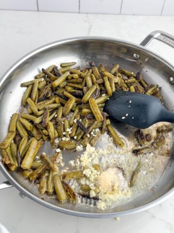canned green beans, butter, garlic, and onion powder in a stainless steel skillet.