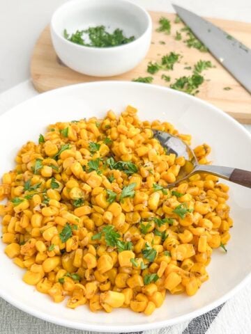sauteed canned corn in a white bowl.