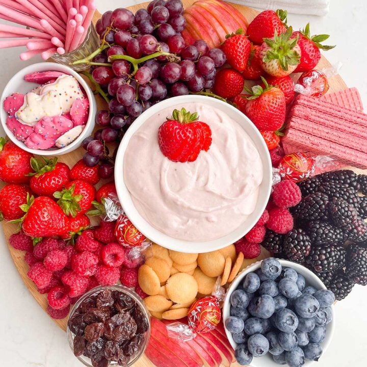 strawberry marshmallow fluff in a white bowl on a fruit board