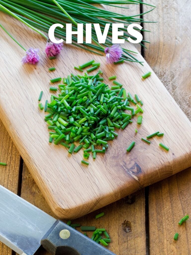 sliced chives on a wood cutting board with a knife