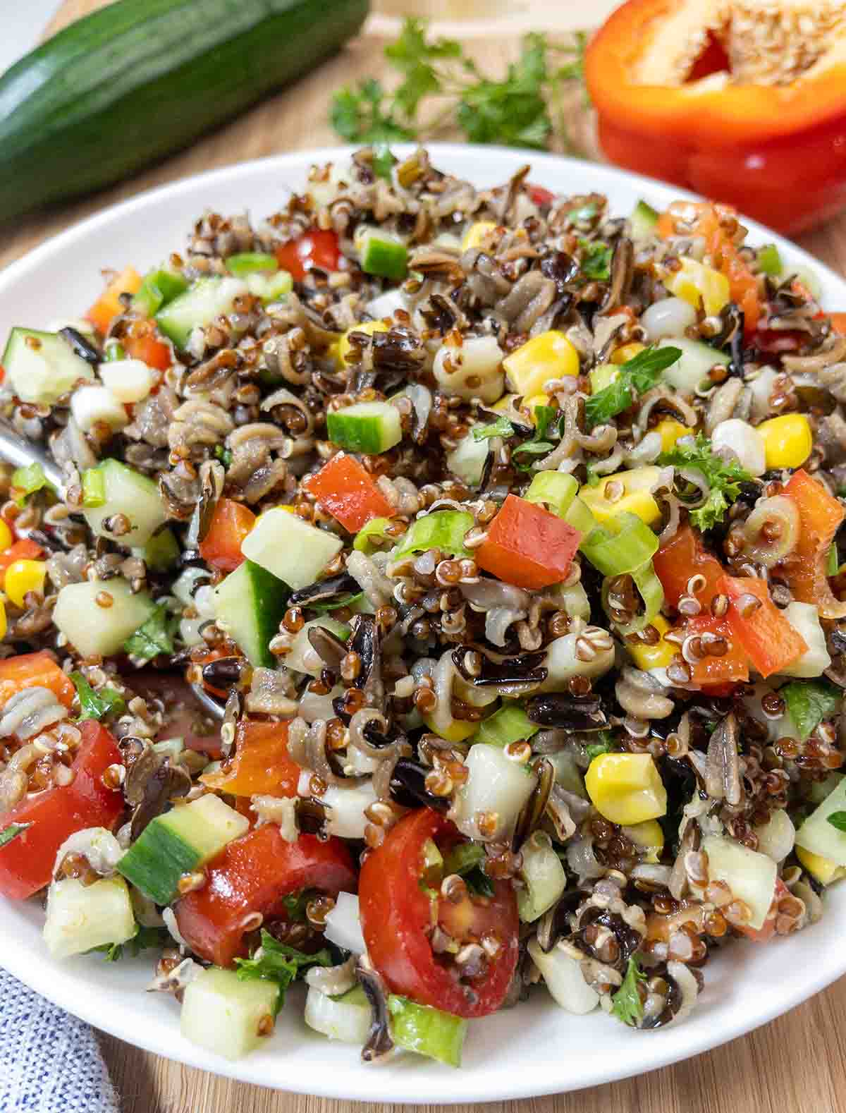 zesty quinoa salad in a white bowl