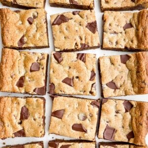 Toll House cookie bars on white parchment paper next to a knife