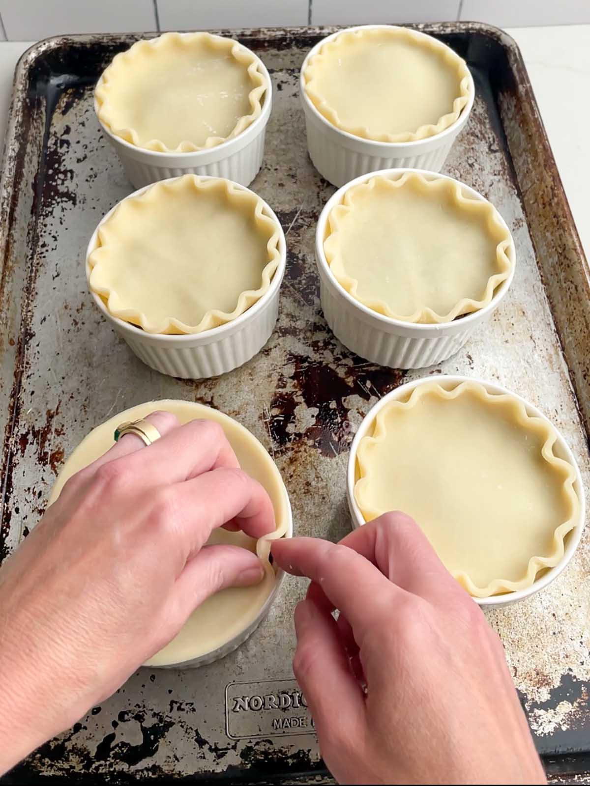 hands fluting the edges of pie crust