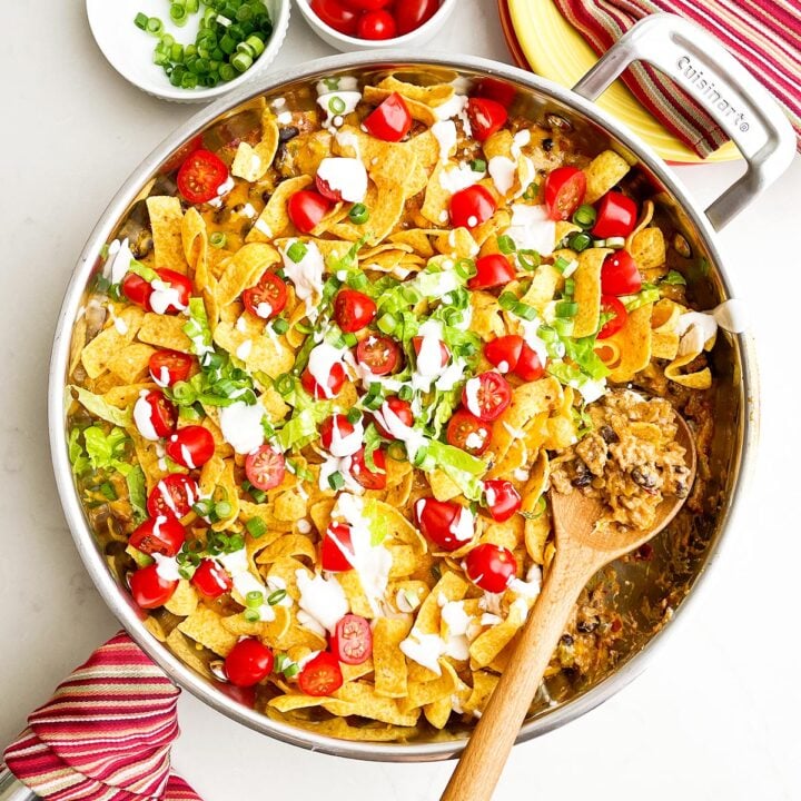 walking taco casserole with fritos in a skillet