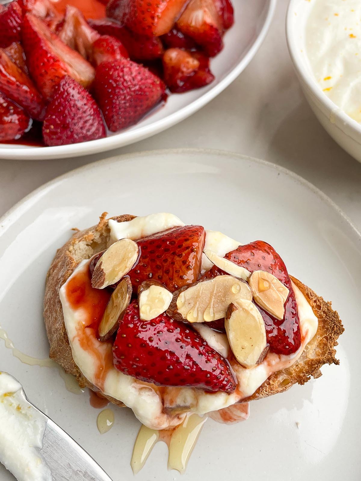 toast topped with whipped ricotta, balsamic roasted strawberries, toasted almonds, and honey.